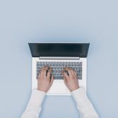 Hands typing on a laptop Woman working and typing on a laptop, top view