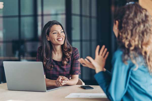 Businesswomen talking in the office conducting stay interview