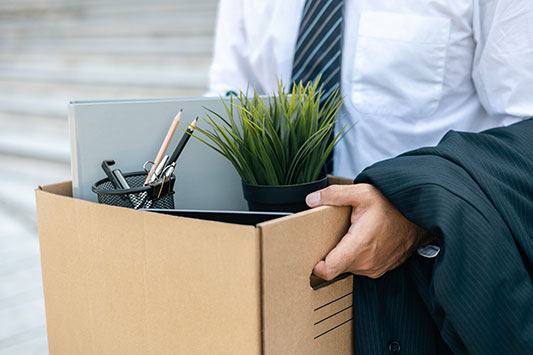 Pharma Sales Rep holding a box of personal effects after quitting.