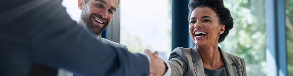 Sales leader shaking hands with a new life sciences sales rep during onboarding.