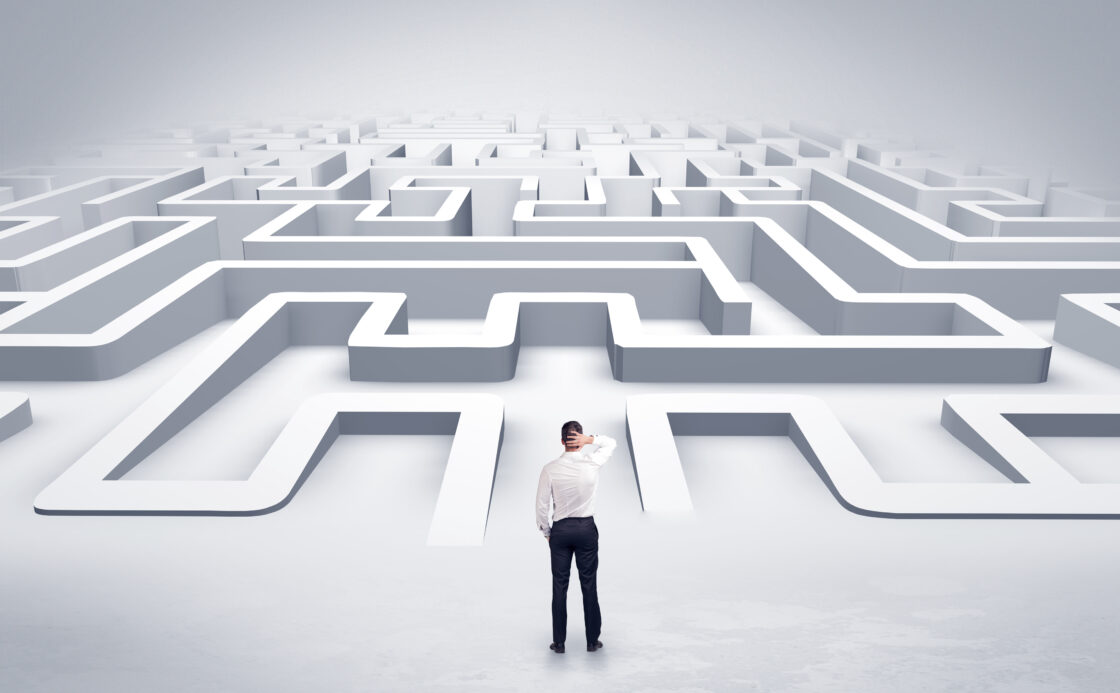 Confused man standing in front of a maze, depicting a complicated sales process