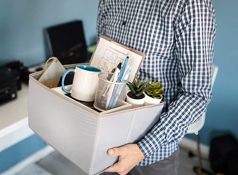 Pharma sales rep carrying a box of personal items after quitting