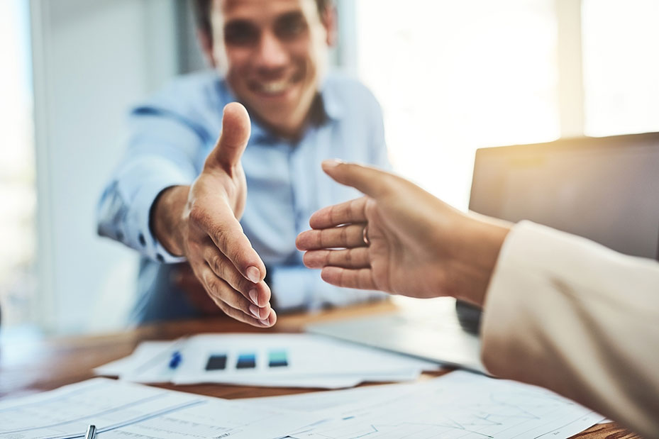 Salesperson shaking hands with a client over a closed deal