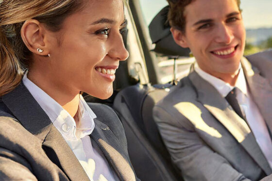 Male and female sales rep navigating map in car