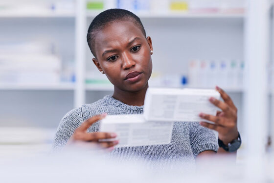 pharmacist looks at medication packaging