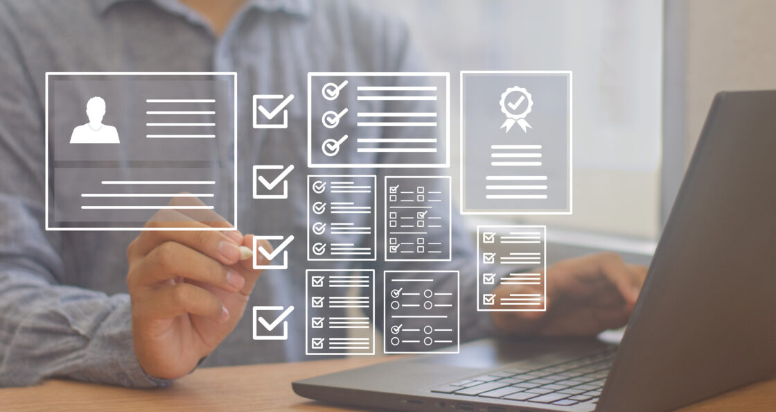 individual sitting on laptop reviewing checklists and documents for product launch