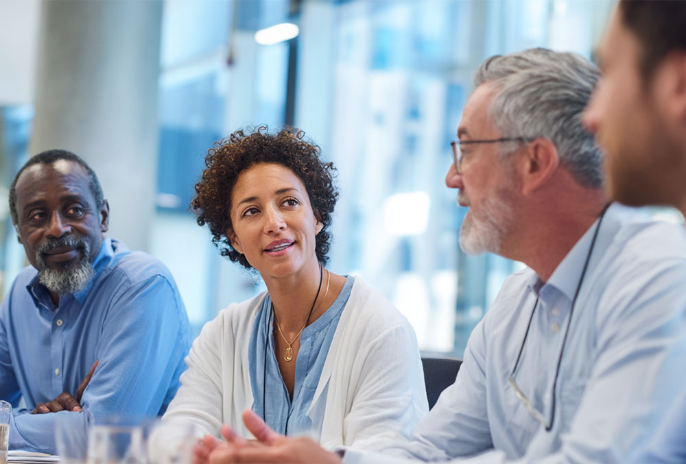 team of sales leaders sitting around a table talking